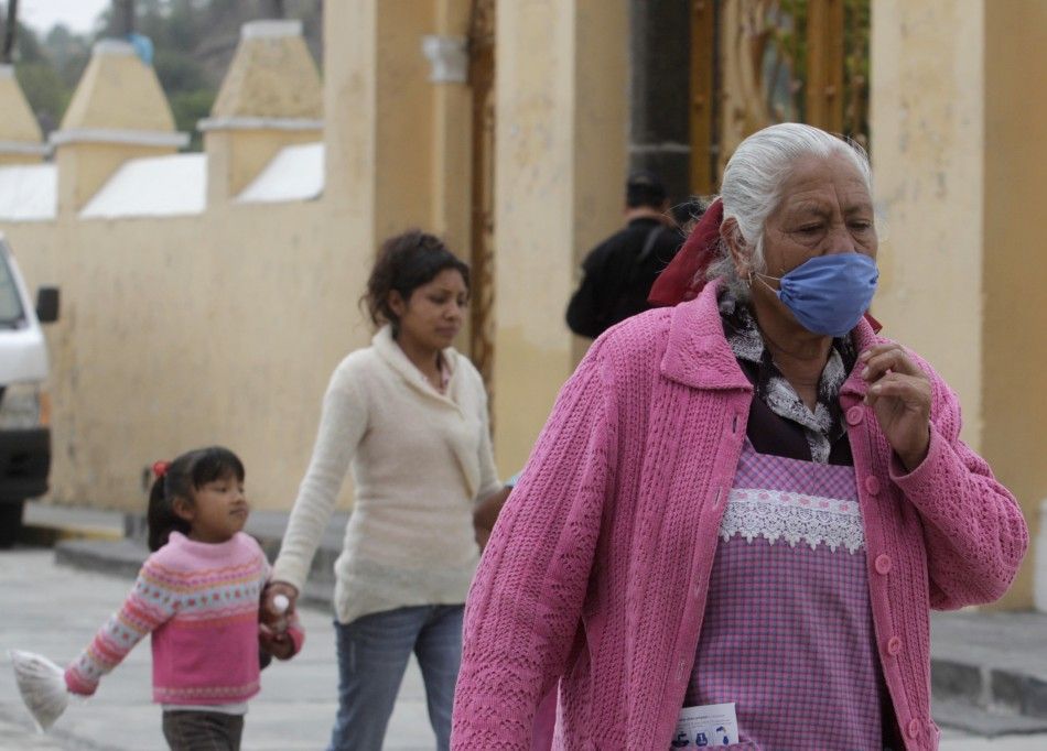 A woman wears a surgical mask while walking in San Nicolas de los Ranchos