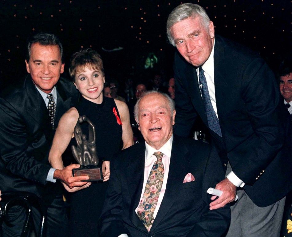 Legendary entertainer Bob Hope, 93, accepts a Lifetime Achievement Award during the Family Film Awards which were telecast live on the CBS TV network August 22. Shown with Hope are L- R TV host Dick Clark, Olympic gymnastics gold medal winner Kerri Stru