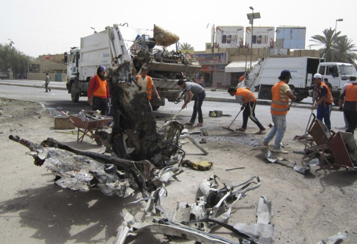 Municipality workers clean the site of a bomb attack on Palestine street in eastern Baghdad