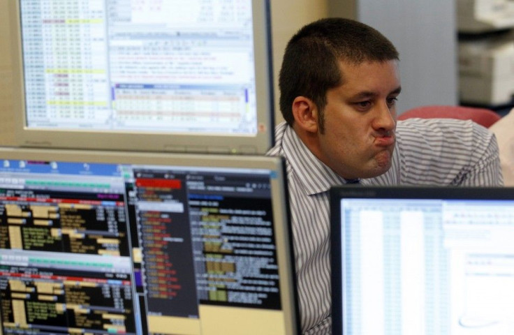 Trader gestures in front of his screens during a bond auction on a trading floor in Madrid