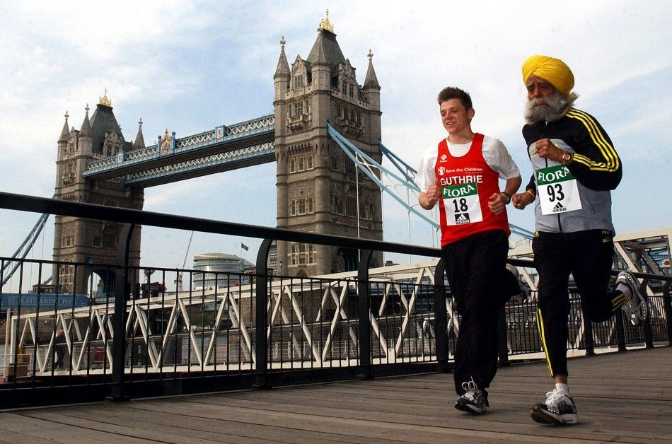 The oldest and youngest runners due to take part in the 2004 London Marathon, 93-year-old Fauja Singh R and Guthrie Brunton who will be 18 on race day, run past Tower Bridge in London, April 16, 2004.