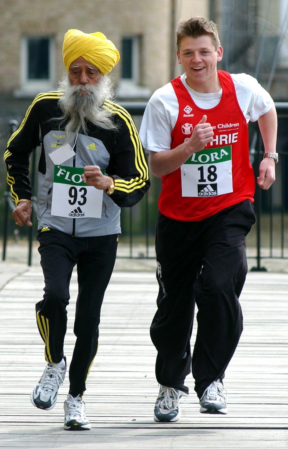 The oldest and youngest runners due to take part in the 2004 London Marathon, 93-year-old Fauja Singh L and Guthrie Brunton who will be 18 on race day, run together in east London, April 16, 2004. 