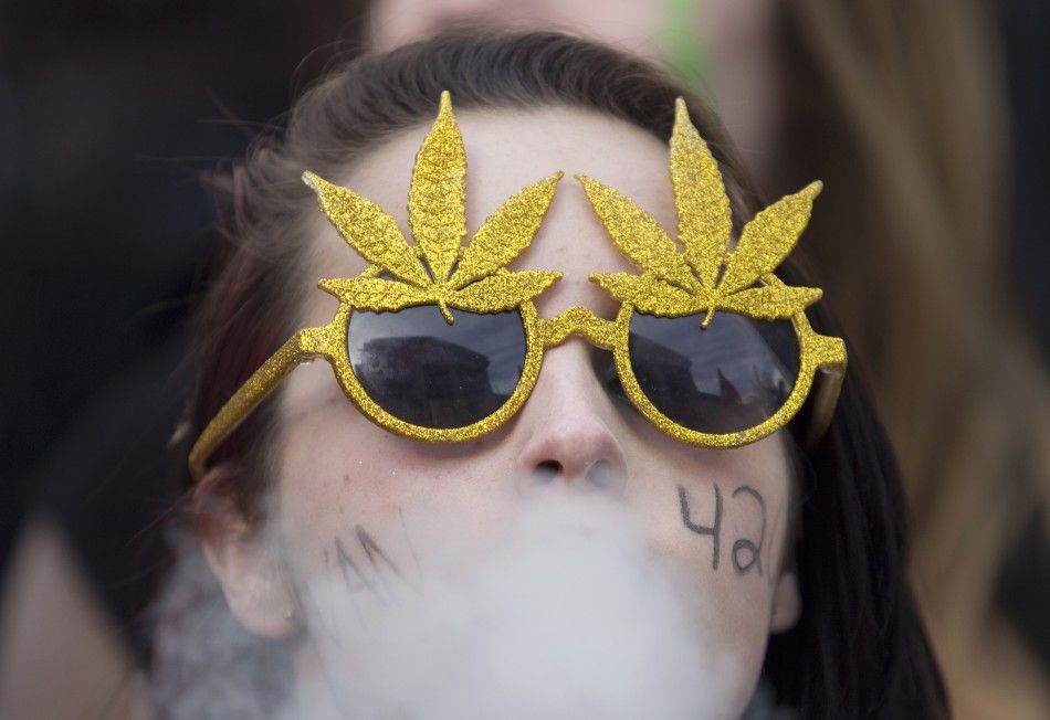 A women wearing novelty sunglasses with artificial marijuana leaves smokes a marijuana joint at the Vancouver Art Gallery