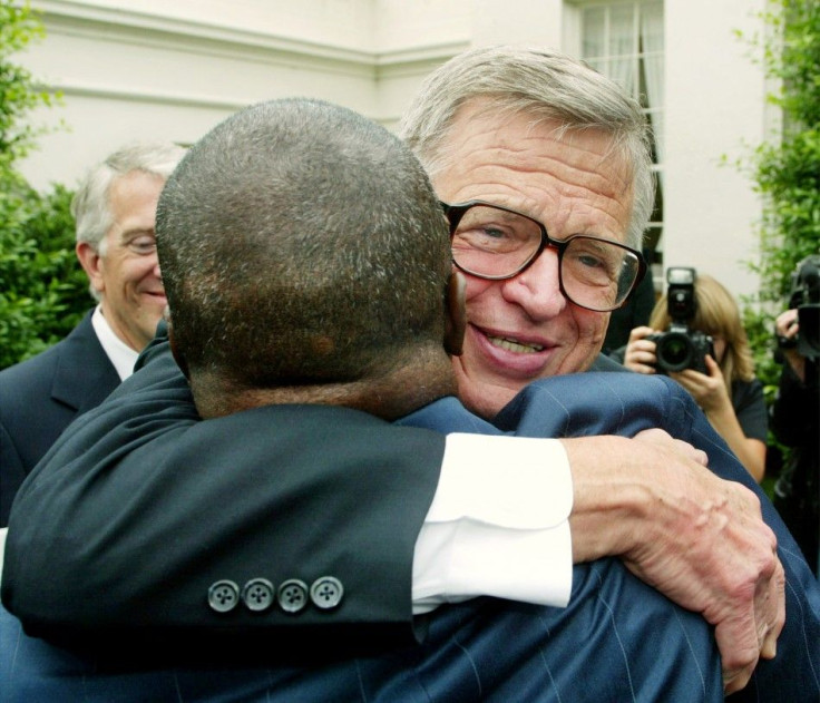 Watergate figure Charles W. &quot;Chuck&quot; Colson, right, hugs former-Texas prison inmate Robert Sutten following a roundtable discussion with U.S. President George W. Bush on Prison Fellowship Ministries outside of the White House, June 18, 2003.