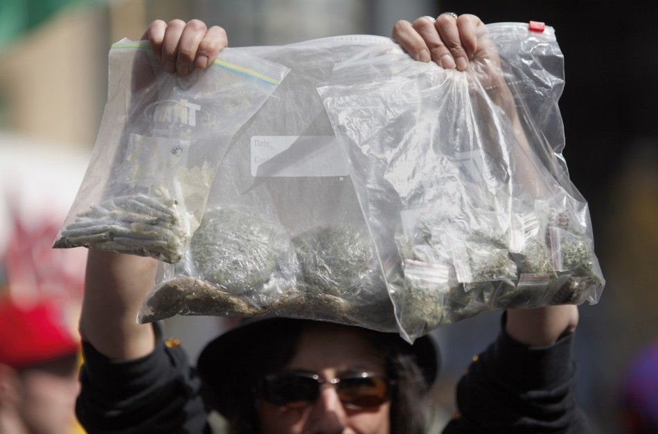 A women holds up bags of marijuana for sale at the Vancouver Art Gallery