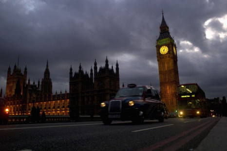A bus and taxi pass Big Ben on Westminster Bridge in London