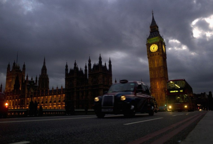 A bus and taxi pass Big Ben on Westminster Bridge in London