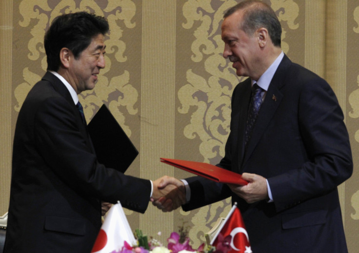 Japan's Prime Minister Shinzo Abe shakes hands with Turkey's Prime Minister Tayyip Erdogan (R) during a signing ceremony in Ankara