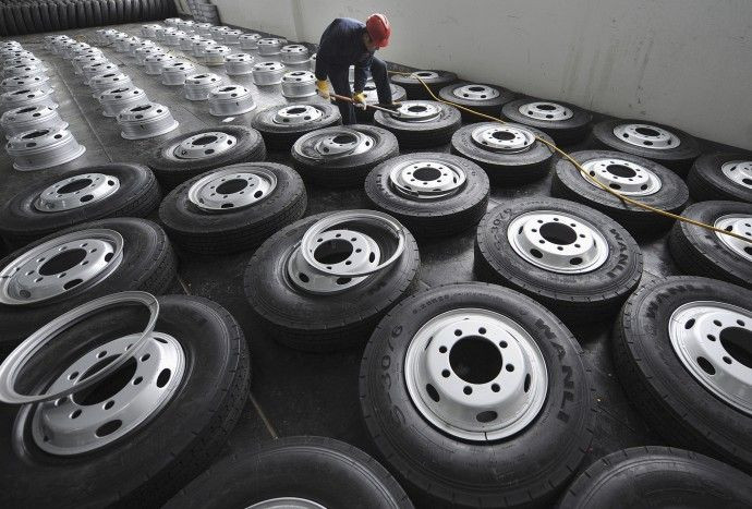 An employee installs tire rims at a factory of Zhengxing Wheel Group in Hefei.