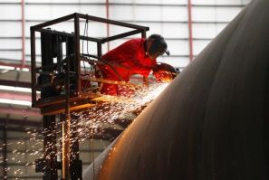 An welder works on a section of a Pelamis wave energy converter at their factory in Edinburgh, Scotland.