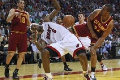 Miami Heat's LeBron James (C) is blocked by Cleveland Cavaliers Samardo Samuels (R) as Cavaliers Anthony Parker (L) looks on during first quarter NBA basketball action in Miami, Florida January 31, 2011.
