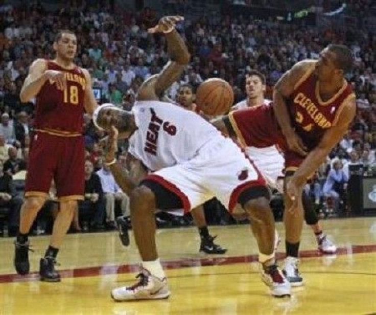 Miami Heat's LeBron James (C) is blocked by Cleveland Cavaliers Samardo Samuels (R) as Cavaliers Anthony Parker (L) looks on during first quarter NBA basketball action in Miami, Florida January 31, 2011.