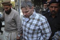 Raymond Davis is escorted by police and officials out of court after facing a judge in Lahore, January 28, 2011