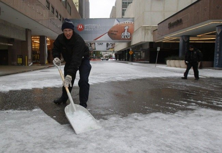 A hotel employee shovels snow from a street in front of a hotel housing news media after a storm front moved through Dallas, Texas, February 1, 2011. Super Bowl XLV is scheduled for February 6 at Cowboys Stadium in nearby Arlington, Texas.