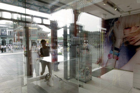 Customers walk into a Swatch shop along the Qianmen shopping street in Beijing