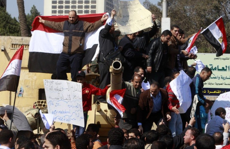 Pro-government supporters of Egyptian President Hosni Mubarak shout slogans atop an army tank near Tahrir square in central Cairo