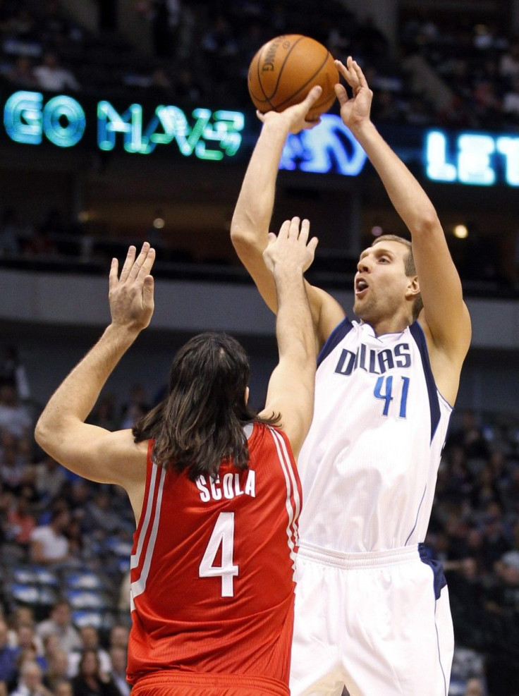 Mavericks power forward Nowitzki shoots over Rockets power forward Scola during their NBA basketball game in Dallas, Texas.