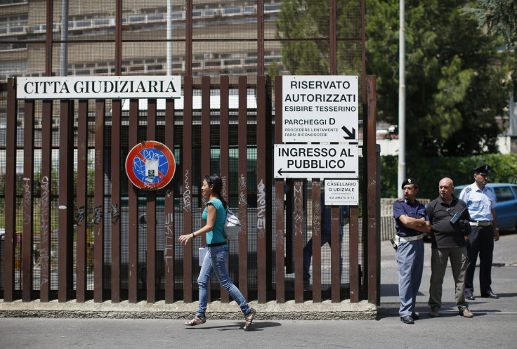 A woman walks past the entrance of the courthouse in Rome June 28, 2013.