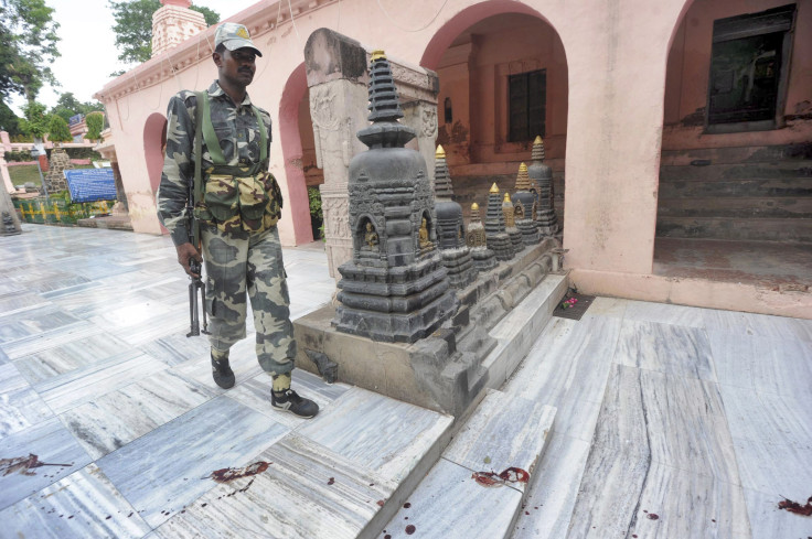 An Indian security personnel walks next to bloody footprints inside the Mahabodhi temple complex, after a series of explosions at Bodh Gaya in the eastern Indian state of Bihar 