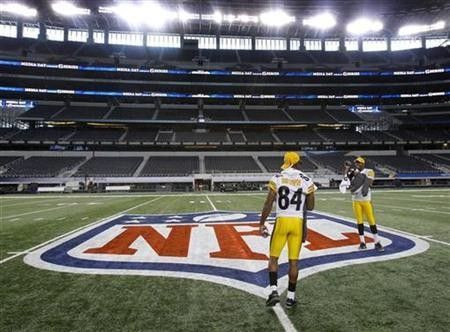 Pittsburgh Steelers back-up quarterback Dennis Dixon records teammate wide receiver Antonio Brown as they walk off the field following media day for Super Bowl XLV at Cowboys Stadium in Arlington, Texas, February 1, 2011.