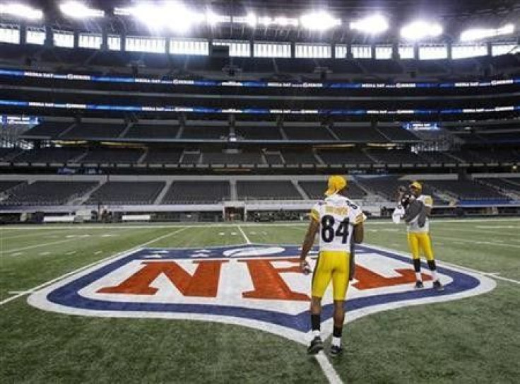 Pittsburgh Steelers back-up quarterback Dennis Dixon records teammate wide receiver Antonio Brown as they walk off the field following media day for Super Bowl XLV at Cowboys Stadium in Arlington, Texas, February 1, 2011. 
