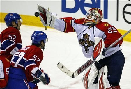 Florida Panthers goalie Tomas Vokoun (29) makes a save as Montreal Canadiens left wing Mathieu Darche (52) and left wing Benoit Pouliot (57) look for a rebound during the second period of their NHL hockey game in Montreal, February 2, 2011.