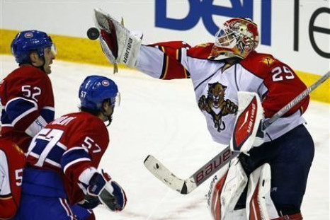 Florida Panthers goalie Tomas Vokoun (29) makes a save as Montreal Canadiens left wing Mathieu Darche (52) and left wing Benoit Pouliot (57) look for a rebound during the second period of their NHL hockey game in Montreal, February 2, 2011. 