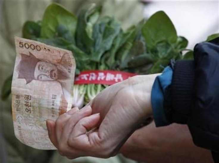 South Korean housewives buy vegetables at a market in Seoul