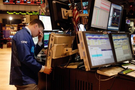 A specialist trader rubs his eyes as he works on the floor of the New York Stock Exchange
