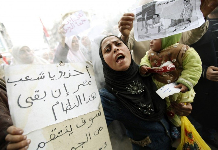 A protester carries her child as she chants anti-government slogans during mass demonstrations against Egypt's President Mubarak in Alexandria