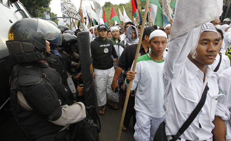 Riot police stand guard as members of the Islamic Defenders Front (FPI) hardline Muslim group take part in a pro-Palestinian rally outside the U.S. embassy in Jakarta