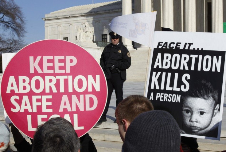 A police officer watches pro-life and pro-choice supporters demonstrating in Washington