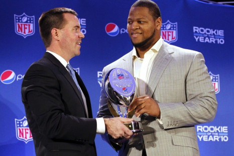 Ndamukong Suh (R) of the Detroit Lions holds the trophy as it was presented by Pepsi Vice President Jeff Dubiel at the Pepsi NFL Rookie of the Year at a news conference in Dallas, Texas, February 3, 2011.