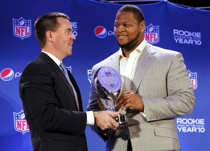 Ndamukong Suh (R) of the Detroit Lions holds the trophy as it was presented by Pepsi Vice President Jeff Dubiel at the Pepsi NFL Rookie of the Year at a news conference in Dallas, Texas, February 3, 2011.