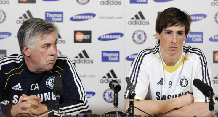 New Chelsea signing Torres listens to questions as he sits with manager Ancelotti during a news conference in Cobham.