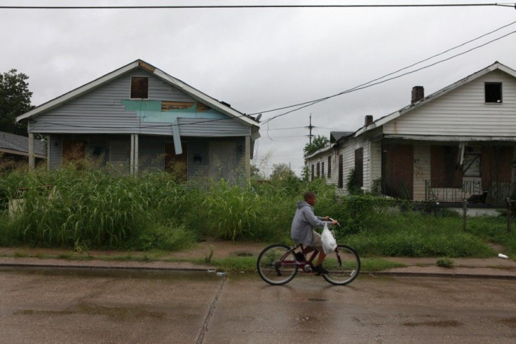 A boy bikes past homes unrepaired since Hurricane Katrina, on the eve of the storm's five year anniversary in the Lower Ninth Ward of New Orleans