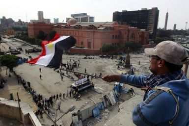 An anti-government protester waves an Egyptian flag at an elevated defense position alongside the Egyptian Museum near Tahrir Square in Cairo February 4, 2011.