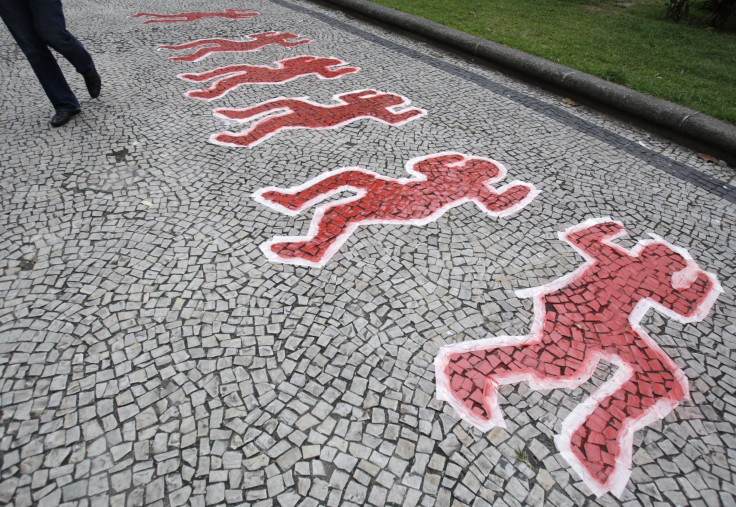 A man walks near paintings to represent street children, who were murdered at the site on July 23, 1993, at Candelaria cathedral in Rio de Janeiro