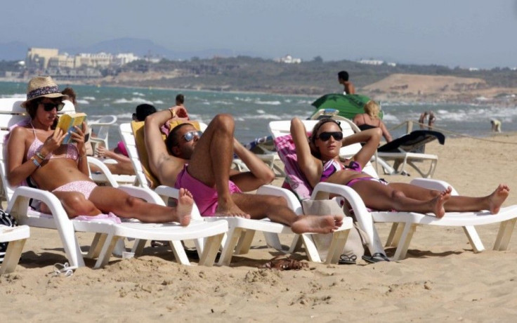 Tourists sunbathe during the first day of Ramadan on Dar Nawar beach near Tunisia's capital, Tunis 