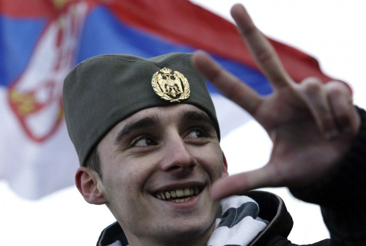 A protester wears traditional Serbian hat as he attends a rally in front of Serbian parliament building in Belgrade