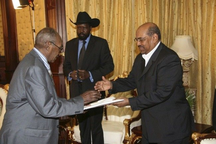 Southern Sudan Referendum Commission (SSRC) chairperson Mohamed Ibrahim Khalil (L) hands out the results of the referendum to Sudan's President Omar Hassan Al Bashir.