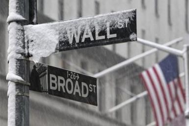 Snow covers a street sign at the corner of Wall St. and Broad St. in New York&#039;s financial district