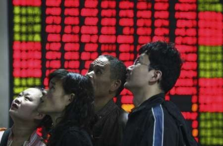 Investors look at an electronic board showing stock information at a brokerage house in Fuyang, Anhui province 