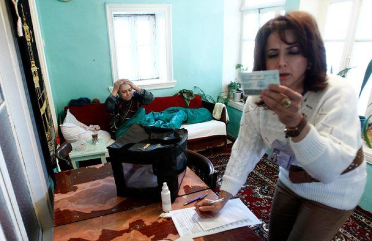 Gulgez Jabrailova, 78, left, waited in her home as an election official checked her ID.