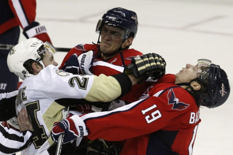 Alex Ovechkin of the Washington Capitals (C) and team mate Nicklas Backstrom (R) retaliate after a trip on Ovechkin by Matt Cooke (L) of the Pittsburgh Penguins during their NHL hockey game in Washington February 6, 2011.