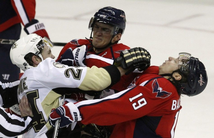 Alex Ovechkin of the Washington Capitals (C) and team mate Nicklas Backstrom (R) retaliate after a trip on Ovechkin by Matt Cooke (L) of the Pittsburgh Penguins during their NHL hockey game in Washington February 6, 2011.