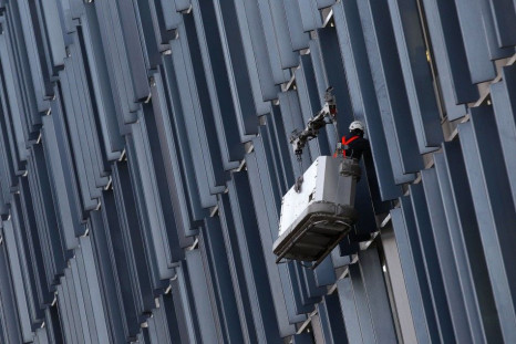 A worker cleans windows on a building in London