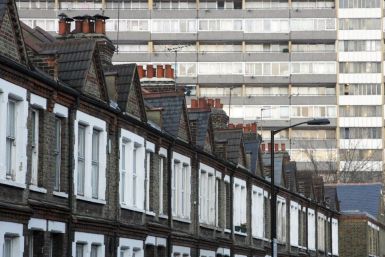 A terraced row of houses is pictured in front of a residential tower block in London