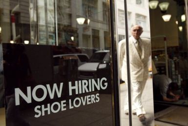 A sign in the window of a retail shoe store advertises for jobs in San Francisco, California