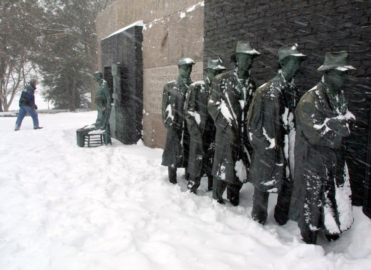 A driving blizzard blows on a Great Depression Bread-Line sculpture as a hiker walks by at the FDR Memorial in Washington